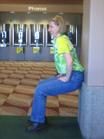 Amy Lesan does a wall sit 
in the airport.